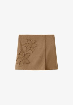 Mini-jupe marron trapèze avec deux grandes découpes florales brodées sur le côté gauche, dotée d'un panneau avant propre à effet portefeuille.