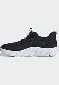 Chaussure de sport noire avec une tige en mesh respirant, une semelle extérieure en caoutchouc blanc et des détails texturés avec des lacets élastiques.
