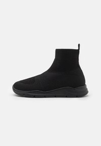 Černé pletené sneakersy po kotníky s texturovaným vzorem, flexibilní podešví a polstrovaným límcem. Obsahuje poutko pro snadné obouvání.