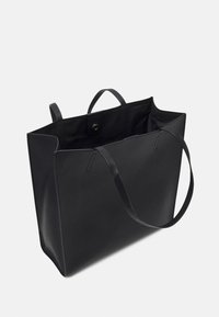Sac fourre-tout en cuir noir avec une surface texturée, un haut ouvert et de longues poignées. Dispose d'une fermeture à pression et d'un intérieur noir uni.