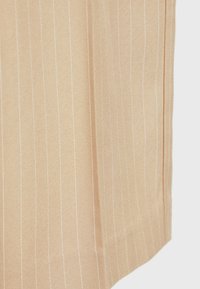 Tissu beige clair avec de subtils rayures blanches, présentant une texture lisse et des bords droit. Aucun accent ni matériel visible.