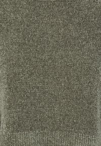 Zielony sweter dziany o teksturowanym, lekko melanżowym wykończeniu. Posiada okrągły dekolt i ściągacz na dole, co nadaje mu miękki wygląd.