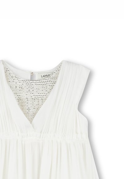 Robe blanche avec un décolleté en V, un design plissé et un panneau arrière en tissu tissé. Le tissu semble léger et texturé avec une taille froncée.