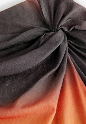 Sõlmes kangast sall, millel on mustast oranžini ulatuv ombre gradient, valmistatud pehmest, tekstureeritud materjalist. Disain on riputatud, rõhutades voldid.