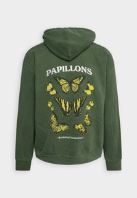 Zelená mikina s kapucí s grafickým motivem motýla v žluté barvě, s nápisem "PAPILLONS" nahoře a textem "Botanická výstava" dole.