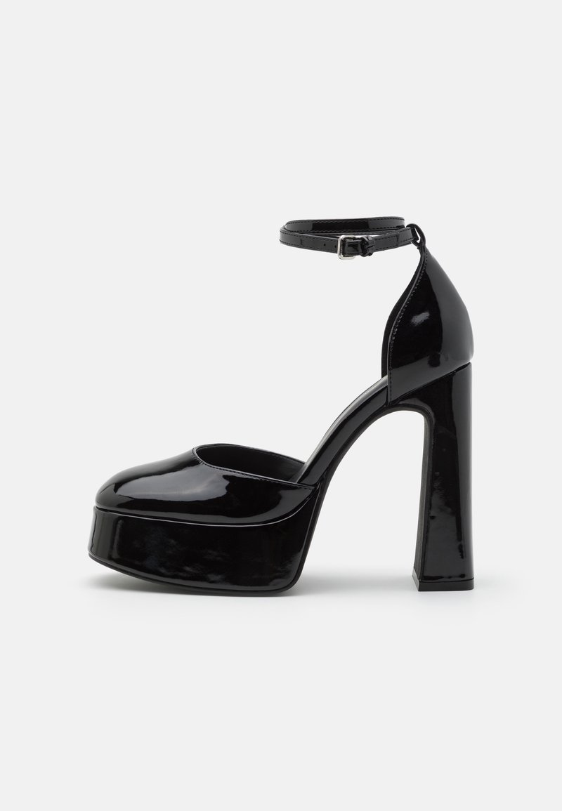 Chaussures compensées en cuir verni noir avec une bride à la cheville, présentant un bout arrondi et un talon carré épais pour plus de stabilité.