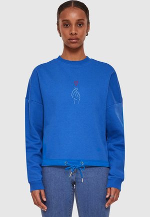 Blue sweatshirt made of soft fabric, featuring a hand graphic and heart design in white and red, with a drawstring hem and ribbed cuffs.