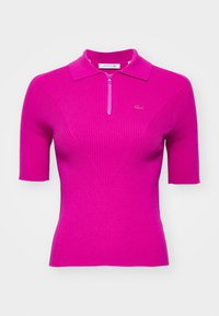 Tajtat kortärmad polo i livlig rosa ribbad material, med en kvart dragkedja och diskret logotypbrodyr på bröstet.
