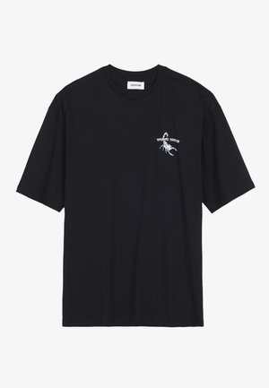 T-shirt noir à manches courtes avec un graphique de scorpion blanc et du texte sur le côté gauche de la poitrine, doté d'un col rond et d'une étiquette de marque visible.