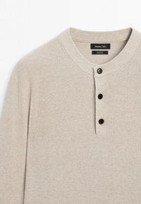 Beiger Baumwollpullover mit Strickmuster, geripptem Rundhalsausschnitt und drei schwarzen Knöpfen auf der vorderen Blende, mit dem Etikett Massimo Dutti.