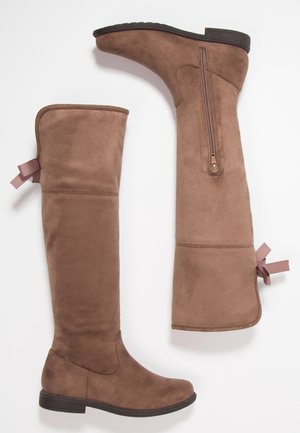 Brown suede knee-high boots with flat black soles, side zipper, and pink ribbon detail on the back near the top.