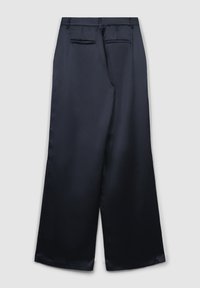 Marineblaue weite Hose mit zwei aufgesetzten Gesäßtaschen und Gürtelschlaufen, flach auf einem hellgrauen Hintergrund präsentiert.
