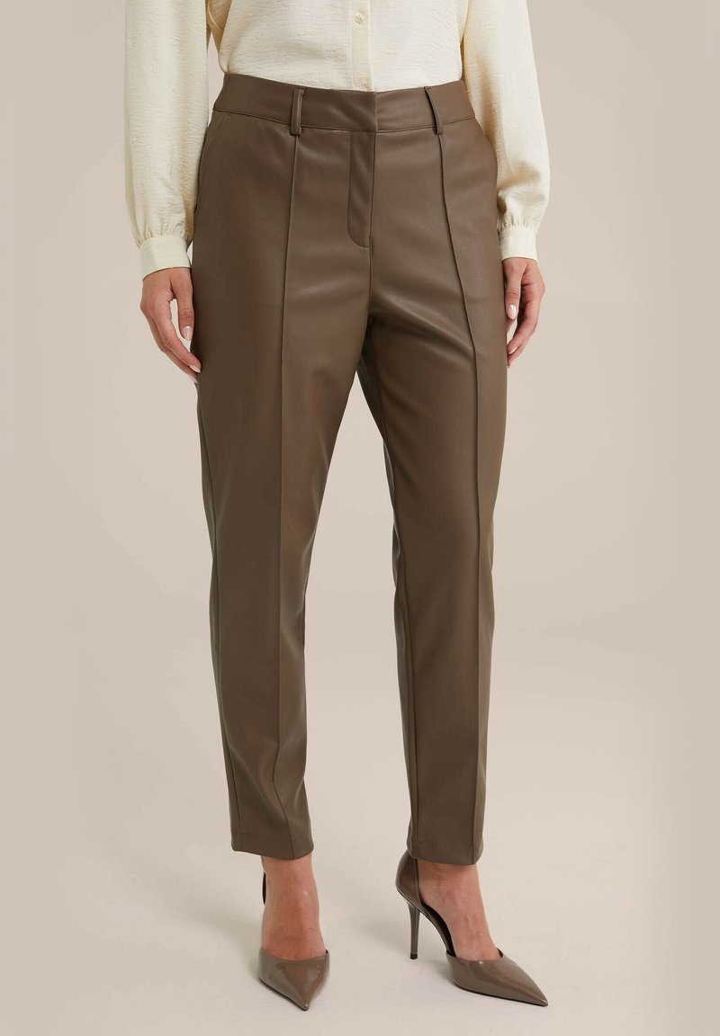Bruine faux leren broek met een slim fit. Bevat voornaad, zijzakken en een zachte textuur. Gepaard met beige hoge hakken.