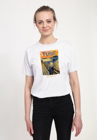 Bílé bavlněné tričko s barevným potiskem „Křik“, se slovem „TUNE“ nahoře a podpisem umělce dole.