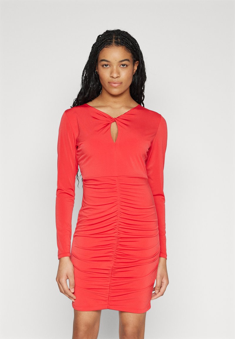 Robe rouge à manches longues avec décolleté en V et une ouverture clé, détails froncés tout au long, et une silhouette ajustée. Fabriquée en un tissu lisse et extensible.