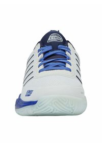 Scarpa sportiva K-Swiss bianca e blu con lacci blu, linguetta blu scuro e suola strutturata, vista frontale.