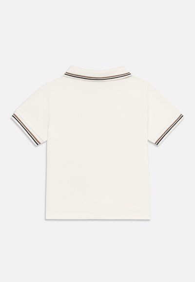 Λευκό μπλουζάκι πόλο με κοντά μανίκια και ρίγες σε μαύρο και καφέ χρώμα στο γιακά και στις άκρες των μανικιών, εμφανιζόμενο από πίσω.