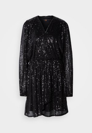 Vestido negro de lentejuelas con escote en V, mangas largas y cintura fruncida. Cae suelto con un dobladillo ligeramente acampanado y superficie texturizada.