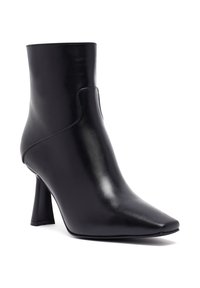 Stivaletto nero realizzato in pelle lucida con punta affusolata e tacco alto a blocco. Le cuciture aggiungono struttura al design.