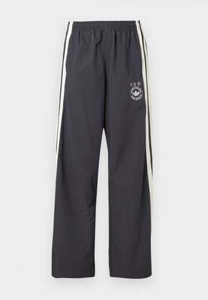 Σκούρο γκρι παντελόνι φόρμας με λευκές πλευρικές ρίγες, ελαστική μέση και κυκλικό λογότυπο με τρία αστέρια στο αριστερό μηρό. Ελαφρύ ύφασμα.