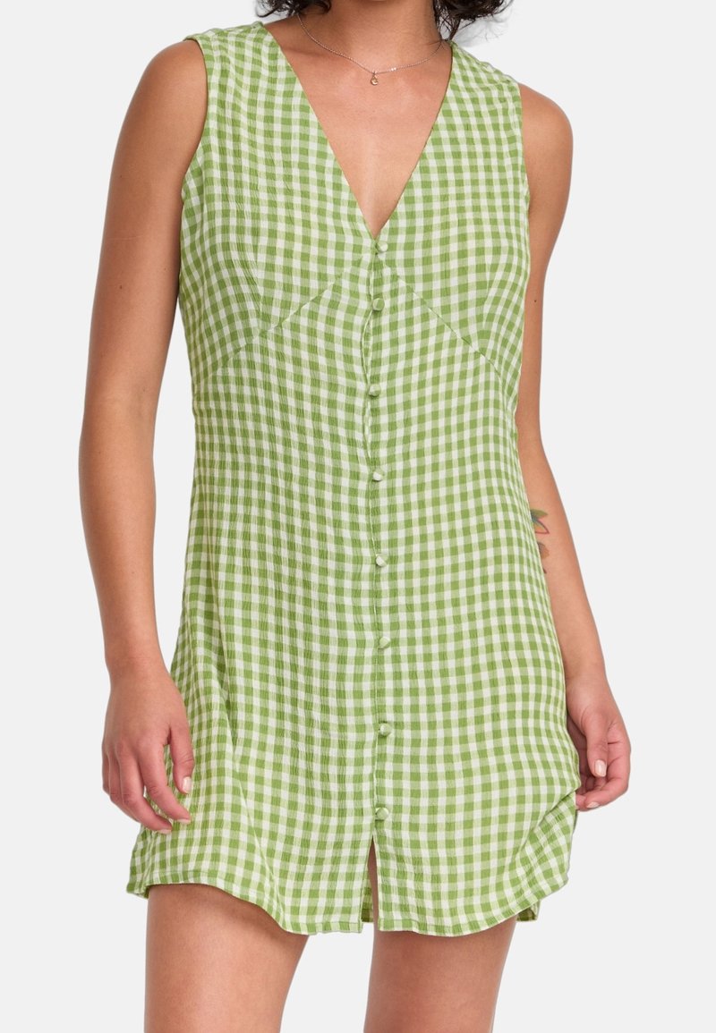 Robe en vichy vert avec un col en V, sans manches et boutons sur le devant. Caractérisée par une coupe décontractée et des fentes sur les côtés pour la mobilité. Tissu en coton.