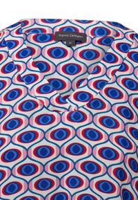 Blusa in cotone con motivo a scollo a V. Presenta motivi ovali blu, rossi e rosa su sfondo bianco. Etichetta visibile all'interno.