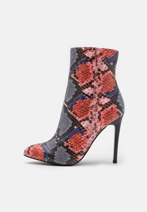 Bottine à talon haut en imprimé serpent multicolore, présentant un bout pointu et une texture lisse avec un talon aiguille noir élégant.