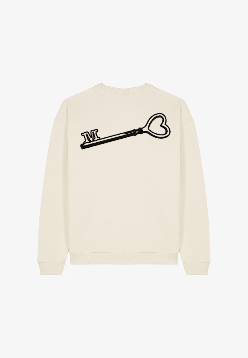 Sweatshirt crème orné d'un design de clé en forme de cœur noir brodé avec la lettre "M" au dos. Tissu doux et poignets côtelés.