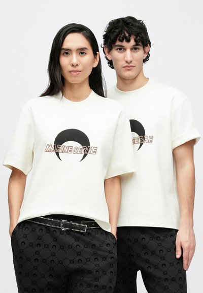 White cotton t-shirts with a black crescent moon graphic and "MARINE SERRE" text. Designed with short sleeves and a relaxed fit.