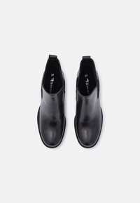 Bottines en cuir noir avec des panneaux élastiques sur les côtés et des languettes de tirage, présentant une texture lisse et un bout arrondi. Taille indiquée comme 37.