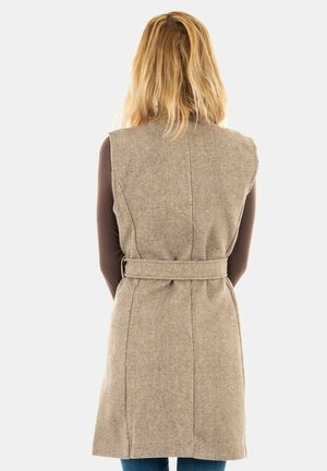 Chaleco de lana sin mangas en color beige con cintura ceñida y cinturón, que presenta una textura suave y un diseño entallado, visto desde la parte de atrás.