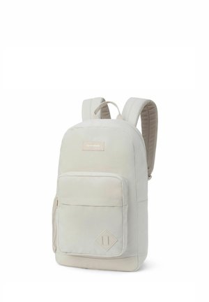 Zaino beige chiaro realizzato in tessuto resistente, dotato di spallacci imbottiti, scomparto principale, tasca frontale con zip e accento a forma di diamante.