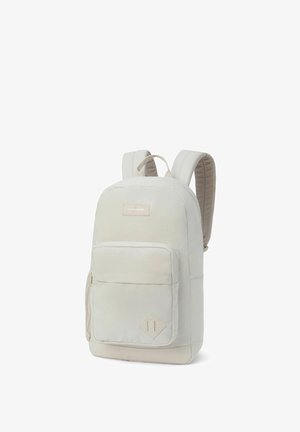Mochila de un beige claro hecha de un tejido duradero, con correas acolchadas, un compartimento principal, un bolsillo frontal con cremallera y un acento en forma de diamante.