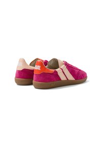 Paire de baskets en suède rose avec des bandes beiges, languettes orange et beige au talon, semelles en caoutchouc marron et logo blanc sur les languettes du talon.