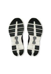 Semelles de chaussures de sport noires avec un motif de texture antidérapant, accents blancs et un composant de rembourrage central pour le confort et le soutien.