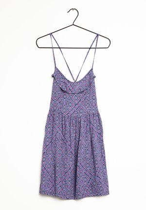 Ärmlös klänning med ett geometriskt mönster i nyanser av lila, rosa och blått. Lättvikts tyg och detaljer med volang vid halsringningen.
