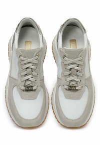 Baskets blanches et grises en cuir et en daim, avec des lacets, une semelle en caoutchouc épaisse et un accent de logo en ton doré.