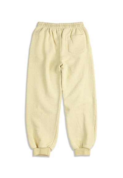 Pantalon de jogging en polaire beige avec taille élastique, poignets côtelés et une seule poche arrière sur fond blanc uni.