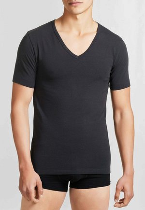 T-shirt nera a maniche corte con scollo a V in tessuto morbido e liscio. Presenta un design aderente e una rifinitura sottile all'orlo che arriva alla vita.