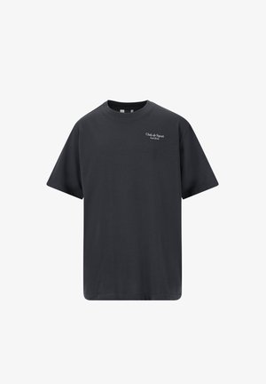 Marineblå bomulds T-shirt med afslappet pasform, korte ærmer og et lille logo. Sættet er kombineret med sorte shorts, hvide sneakers og mønstrede strømper.