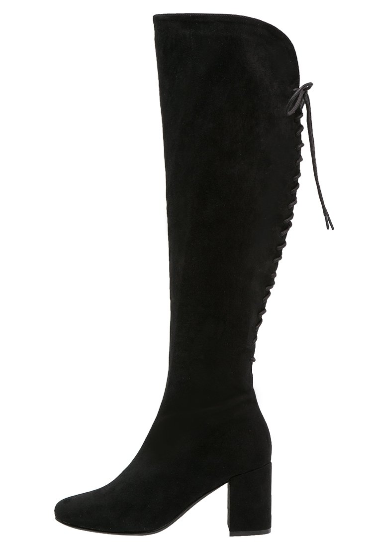 Stivale sopra il ginocchio in suede nero con tacco a blocco, caratterizzato da una parte superiore curva e dettagli con lacci lungo il lato esterno.