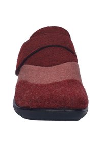 Red and pink felt slippers with a velcro strap, featuring a rounded toe and a black rubber sole. Soft texture with layered color design.