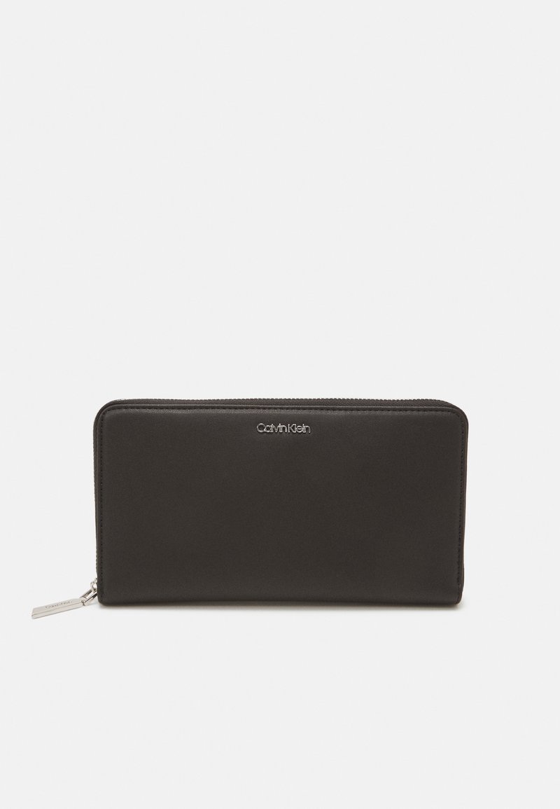 Black leather wallet with a smooth texture, rectangular shape, zip closure, and a silver logo on the front. Compact and minimalist design.