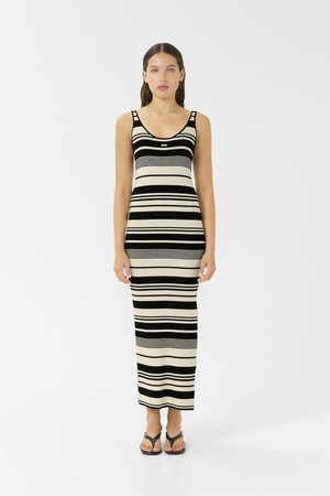Robe maxi en tricot rayée en noir et beige avec un décolleté rond et de larges bretelles. Présente des rayures horizontales et une silhouette ajustée.