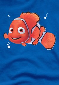 Illustration eines orangefarbenen Clownfischs auf blauer Stoffoberfläche, mit auffälligen weißen Streifen, großen Augen und kleinen Blasen im Hintergrund.