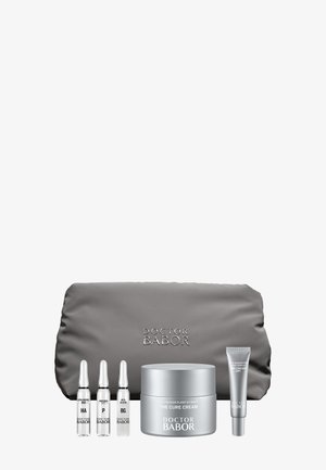 Ensemble de soins de la peau Doctor Babor comprenant trois ampoules, un pot de The Cure Cream, un tube de crème pour les yeux et une pochette grise de la marque.
