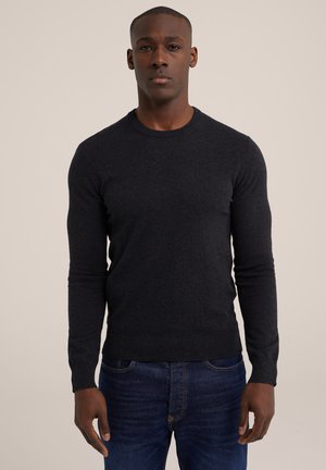 Donkergrijs sweater van zachte breimateriaal met een ronde halslijn en lange mouwen, gecombineerd met blauwe jeans. Slank aansluitende silhouet, minimalistisch ontwerp.