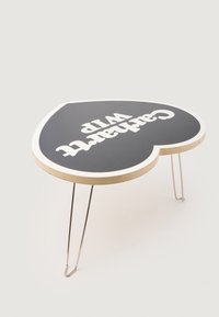 Tavolo a forma di cuore con piano nero caratterizzato da testo bianco, bordi in legno e gambe in metallo sottili. Design pulito e estetica minimalista.