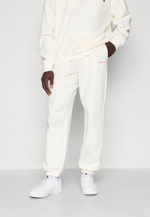 Biela bavlnená mikina a zodpovedajúce tepláky s červeným logom "BJÖRN BORG". Elastické manžety a voľný strih. Biele tenisky dopĺňajú vzhľad.