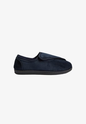 Navyblauwe slipper met een textuurstof bovenkant, flexibele zwarte zool en een opvouwbare bovenrand voor eenvoudig aan- en uittrekken. Het ontwerp staat in het teken van comfort en toegankelijkheid.